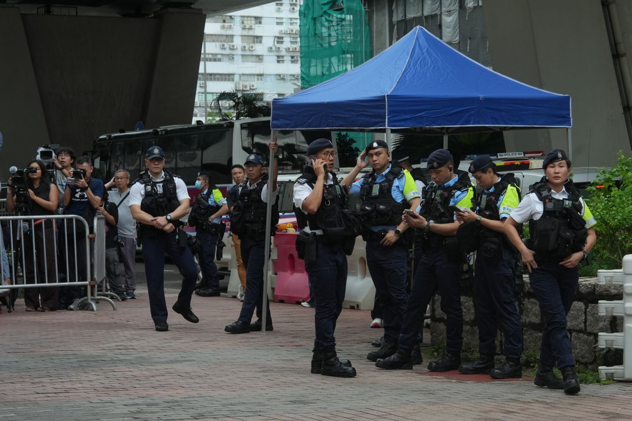 Hong Kong woman arrested for seditious T-shirt outside court as democracy advocates face conviction